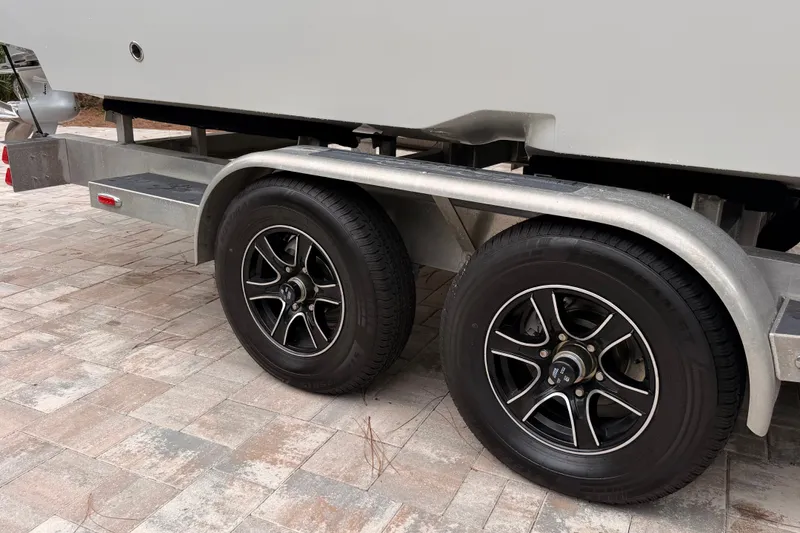 Slide: The Image of Trailer wheels of a 2021 Costa Custom Boats 264HC on a paved surface. - 40