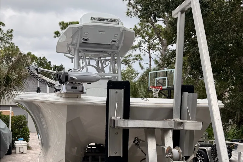 Slide: The Image of Costa Custom Boats 264HC 2021 model on trailer, surrounded by trees and a basketball hoop. - 22