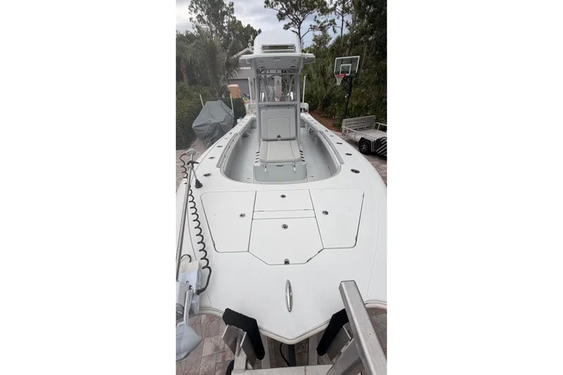 Slide: The Image of 2021 Costa Custom Boats 264HC, white deck, parked outdoors with trees and basketball hoop. - 29