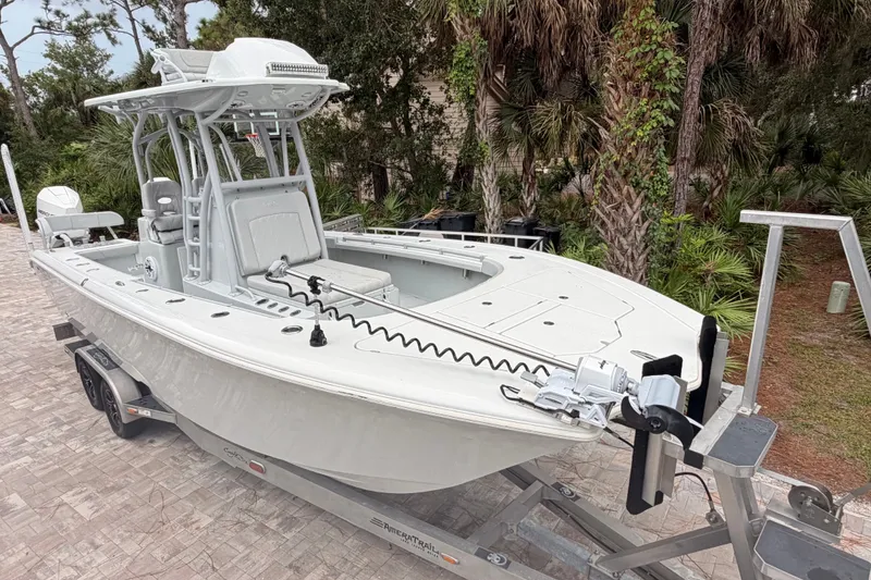 Slide: The Image of 2021 Costa Custom Boats 264HC on trailer, surrounded by lush greenery. - 7