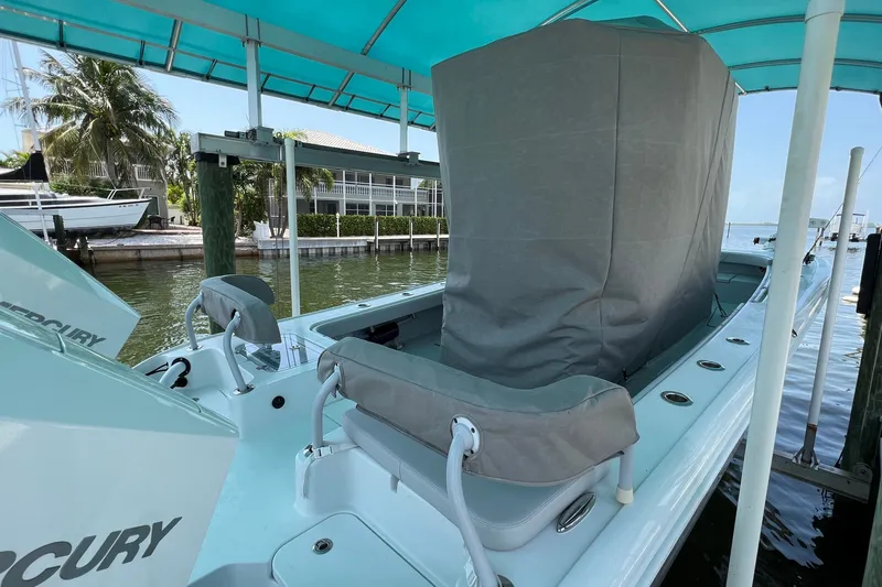 Slide: The Image of 2021 Costa Custom Boats 264HC docked under a canopy, featuring covered seating and Mercury engines. - 5