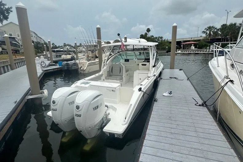 Slide: The Image of 2025 Pursuit DC 266 Dual Console boat docked with twin Yamaha engines. - 3