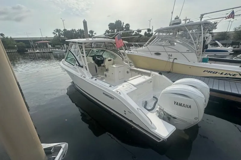 Slide: The Image of 2025 Pursuit DC 266 Dual Console boat docked with Yamaha engines. - 4