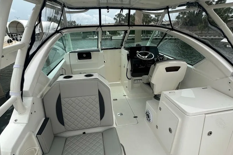 Slide: The Image of 2025 Pursuit DC 266 Dual Console boat interior with seating and steering wheel. - 7