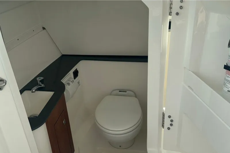 Slide: The Image of 2025 Pursuit DC 266 Dual Console boat bathroom with sink and toilet. - 12