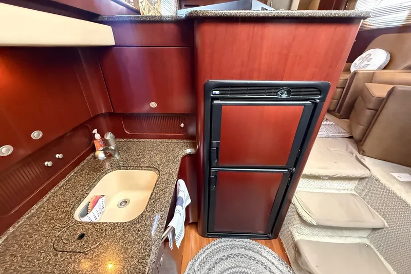 Slide: The Image of 2007 Sea Ray 40 Motor Yacht kitchen with sink, countertop, and compact refrigerator. - 68