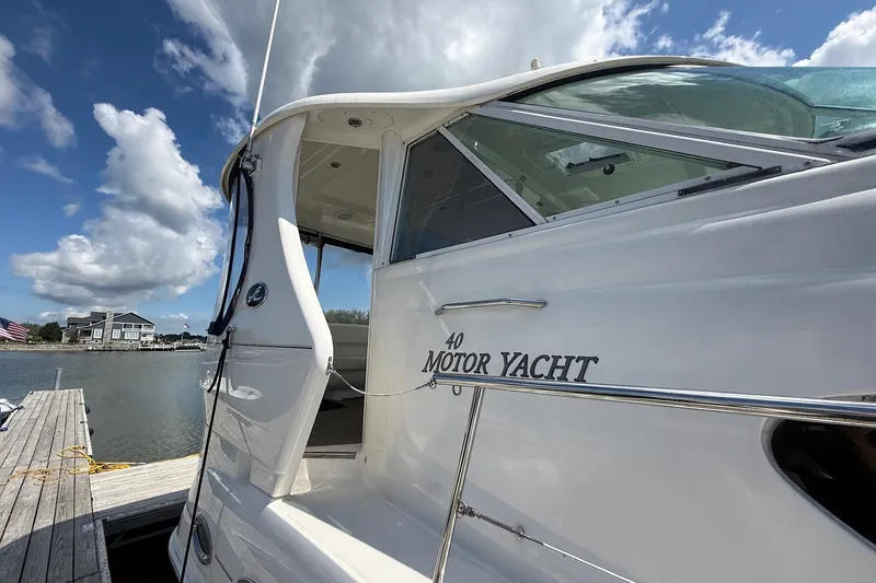 Slide: The Image of 2007 Sea Ray 40 Motor Yacht docked by a serene waterfront under a blue sky. - 17