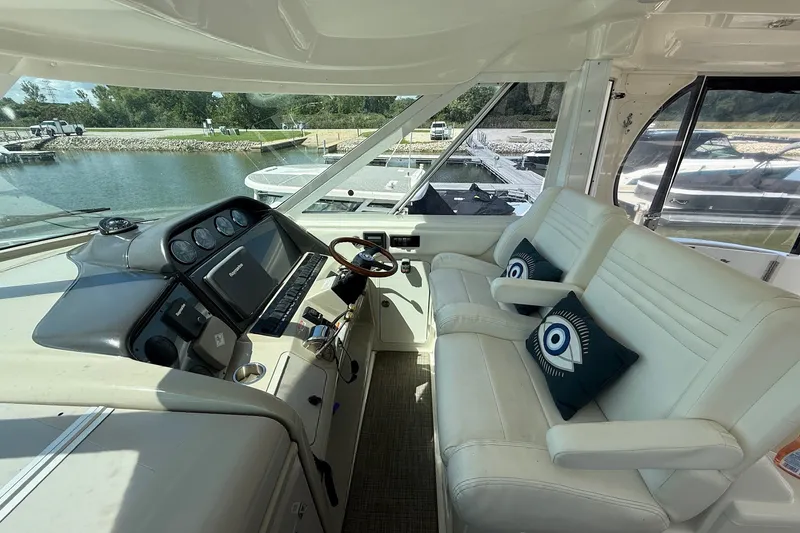Slide: The Image of 2007 Sea Ray 40 Motor Yacht helm with white seating and nautical-themed cushions. - 40