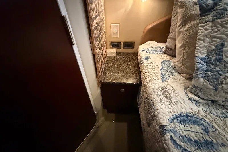 Slide: The Image of Cozy cabin interior of 2007 Sea Ray 40 Motor Yacht with patterned bedding and bedside table. - 85