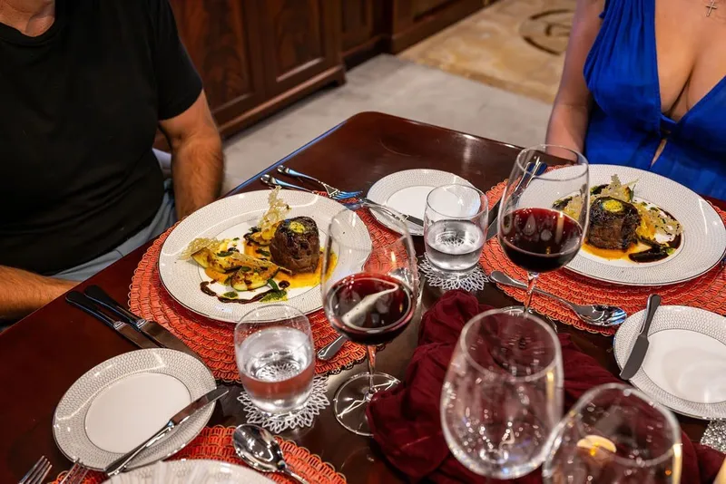 Slide: The Image of Elegant dining setup on Benetti 120 Classic yacht, featuring gourmet meals and red wine. - 142
