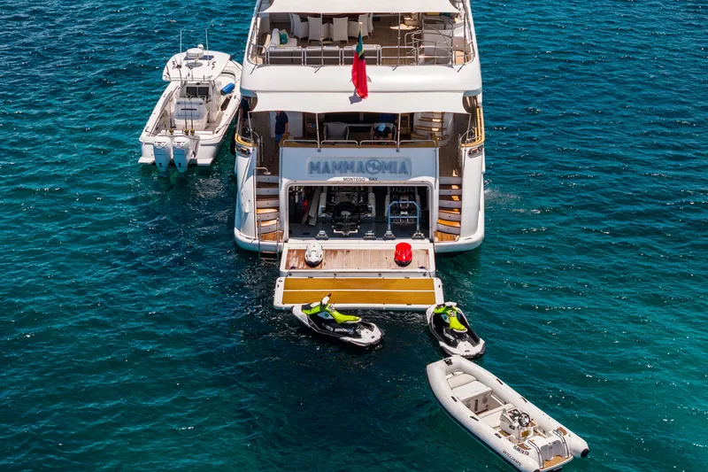 Slide: The Image of Luxury yacht Benetti 120 Classic 2007 with jet skis and boats in clear blue water. - 7