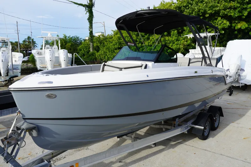 The Image of 2027 Monterey Elite 23 OB boat on trailer, sleek design, parked outdoors. - 0