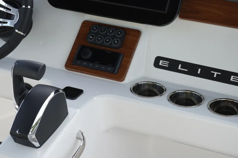Slide: The Image of Control panel of 2027 Monterey Elite 23 OB boat with steering and cup holders. - 11