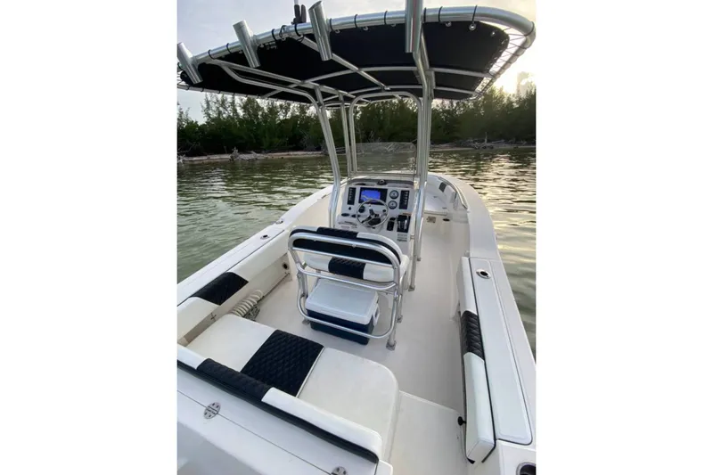 Slide: The Image of 2018 Robalo R202 Explorer boat interior with console and seating, near shoreline. - 3