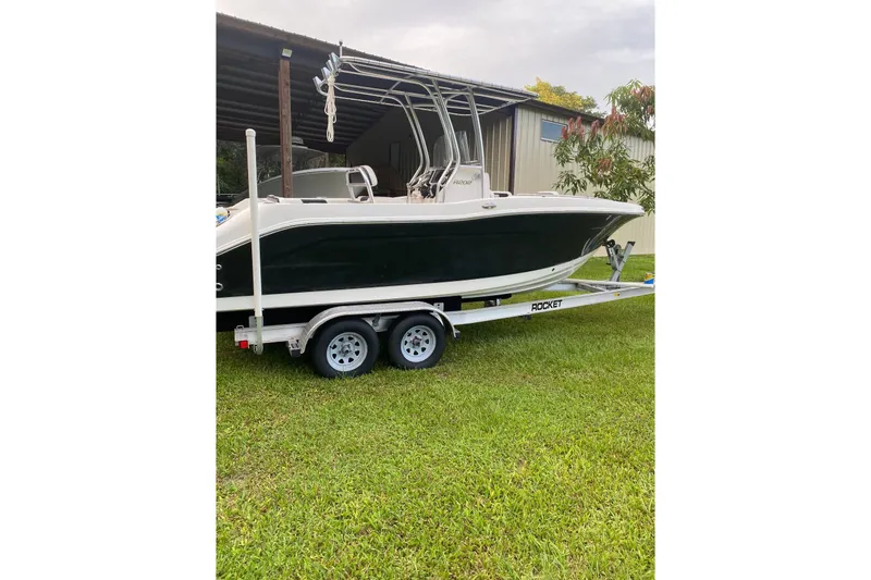 Slide: The Image of 2018 Robalo R202 Explorer boat on trailer, parked on grass. - 10
