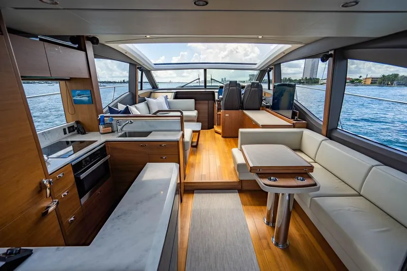 Slide: The Image of Interior of a luxury yacht with wooden floors, white sofas, and large windows overlooking the water. - 19