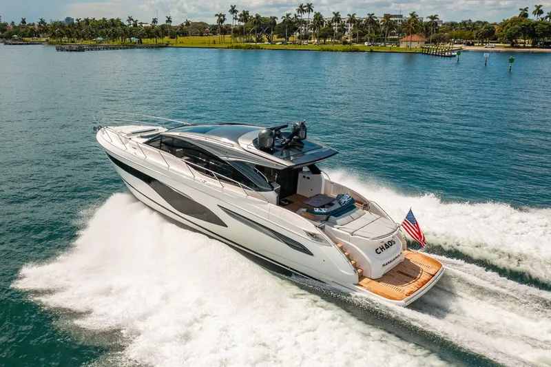 Slide: The Image of De Princess V60 uit 2020 glijdt elegant over het water, omgeven door een schilderachtig kustlandschap. - 4