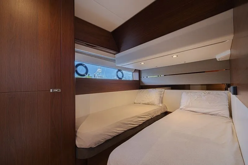 Slide: The Image of Luxurious 2020 Princess V60 yacht cabin with twin beds and elegant wood finish. - 23