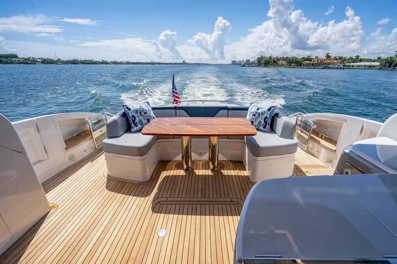 Slide: The Image of The image shows the stern of a luxury yacht with a wooden table and cushioned seating. - 8