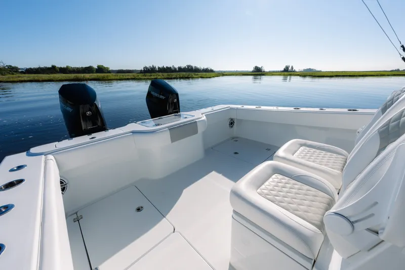 Slide: The Image of 2023 Freeman 34VH boat interior with dual Mercury engines on calm water. - 23