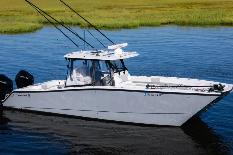 The Image of 2023 Freeman 34VH boat on calm water, featuring dual Mercury engines. - 0
