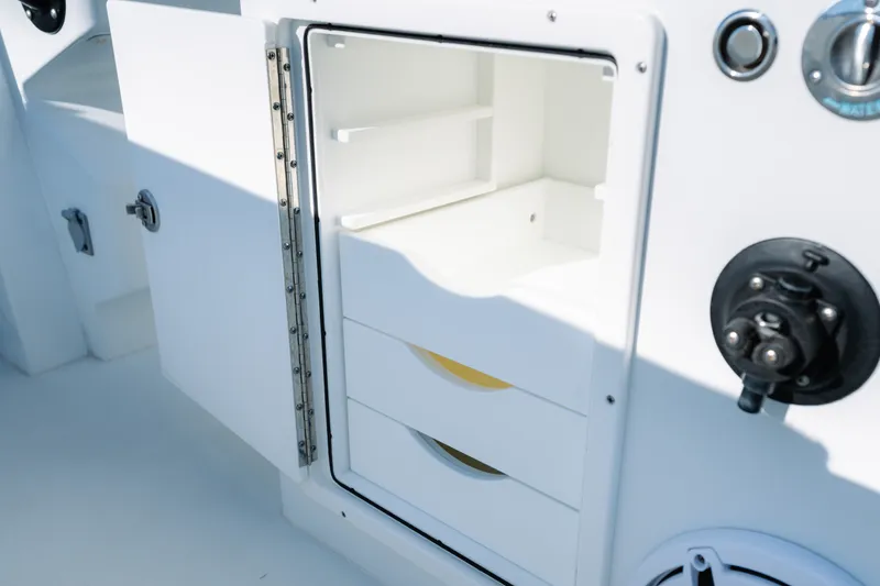 Slide: The Image of Open storage compartment on a 2023 Freeman 34VH boat, featuring drawers and shelves. - 24