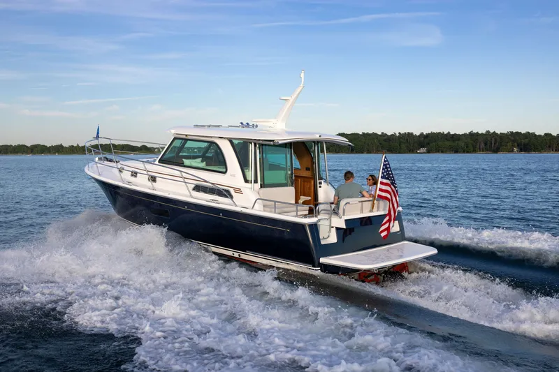 Slide: The Image of 2027 Sabre 38 Salon Express cruising on a lake with two passengers onboard. - 4