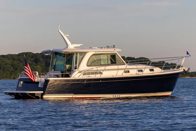 Slide: The Image of Manufacturer Provided Image: 2027 Sabre 38 Salon Express yacht on calm water, featuring sleek design and American flag. - 1