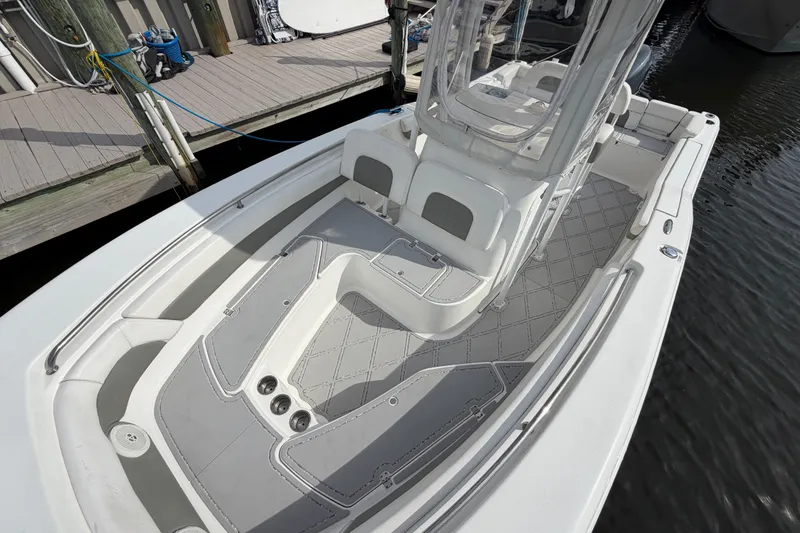 Slide: The Image of 2014 Tidewater 230 LXF boat with spacious deck and modern seating at dock. - 17