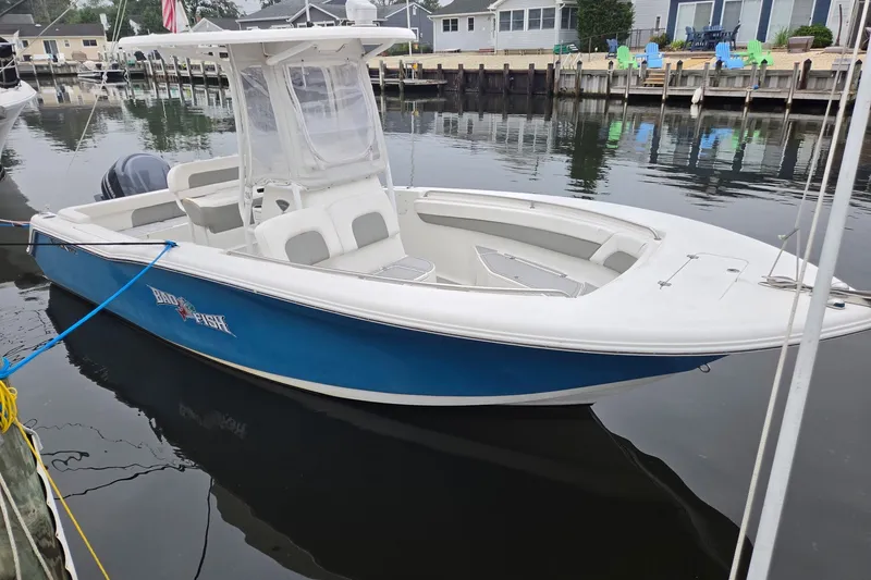The Image of 2014 Tidewater 230 LXF boat docked in a calm marina setting. - 1