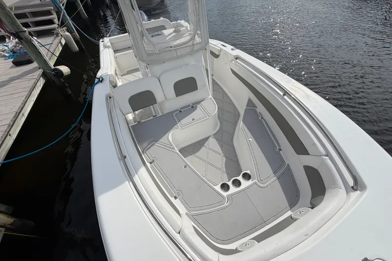 Slide: The Image of 2014 Tidewater 230 LXF boat interior, featuring spacious seating and sleek design by the dock. - 16