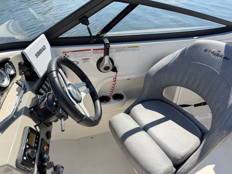 Slide: The Image of The image shows the cockpit of a 2021 Stingray 214 LR boat with a gray seat and steering wheel. - 15