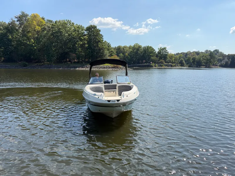 Slide: The Image of A white motorboat with a black canopy cruising on a calm lake. - 9