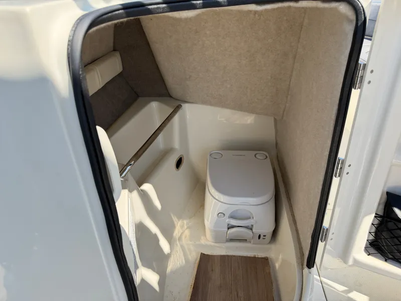 Slide: The Image of The image shows a small boat toilet with beige carpeting and a portable toilet. - 20