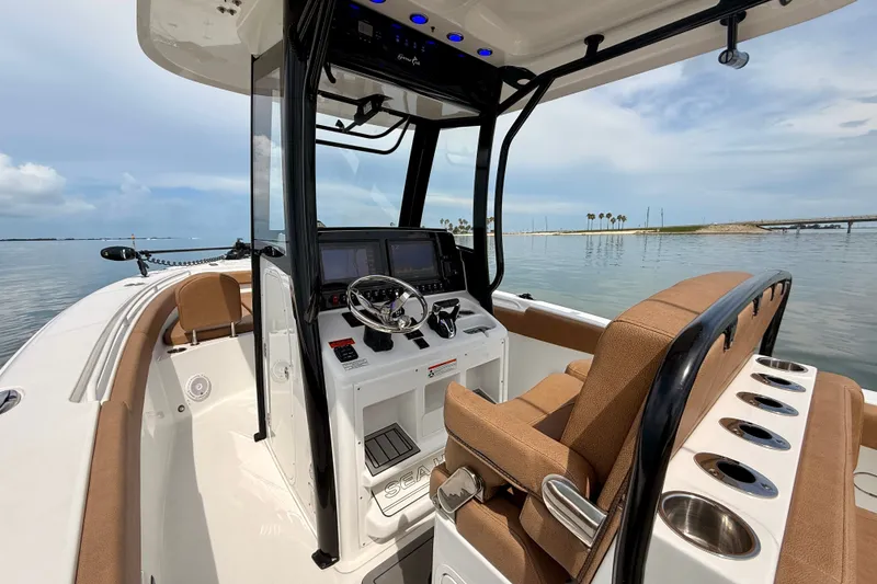 Slide: The Image of 2021 Sea Hunt Gamefish 27FS boat interior with helm, seating, and water view. - 5