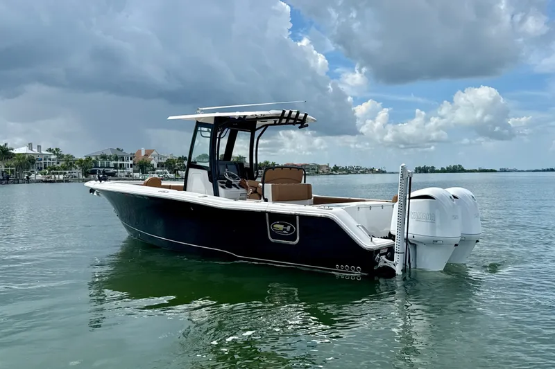 Slide: The Image of 2021 Sea Hunt Gamefish 27FS boat on calm water under cloudy sky. - 23