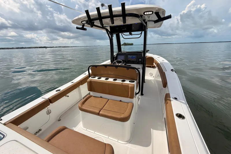 Slide: The Image of 2021 Sea Hunt Gamefish 27FS boat interior with brown seating on calm water. - 4