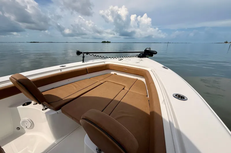 Slide: The Image of 2021 Sea Hunt Gamefish 27FS boat with cushioned seating on calm waters. - 13