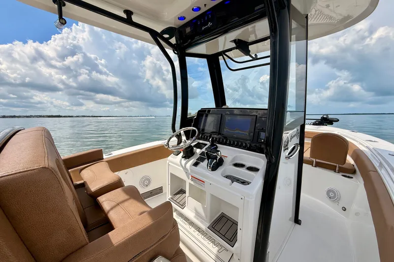 Slide: The Image of 2021 Sea Hunt Gamefish 27FS boat interior with helm, steering wheel, and navigation screens. - 8