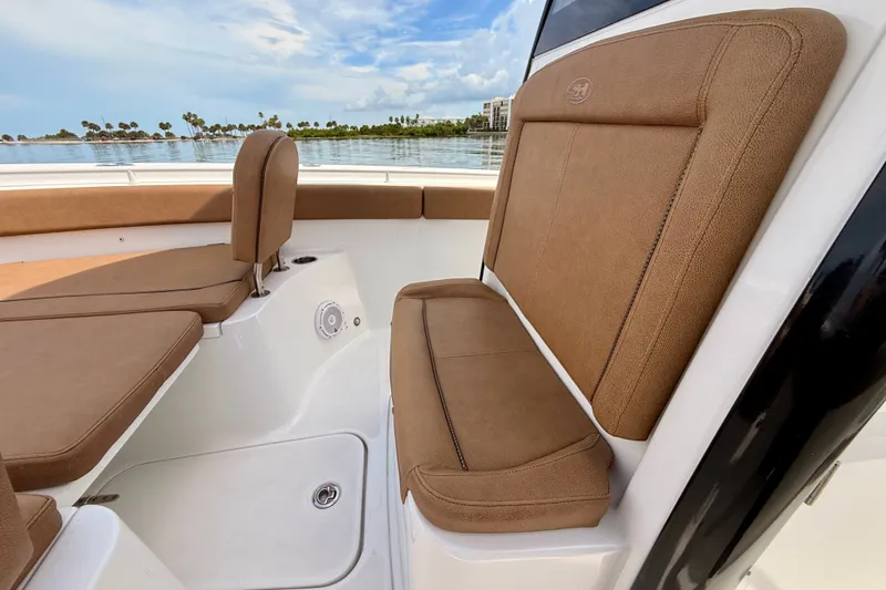 Slide: The Image of 2021 Sea Hunt Gamefish 27FS boat interior with brown cushioned seating. - 14