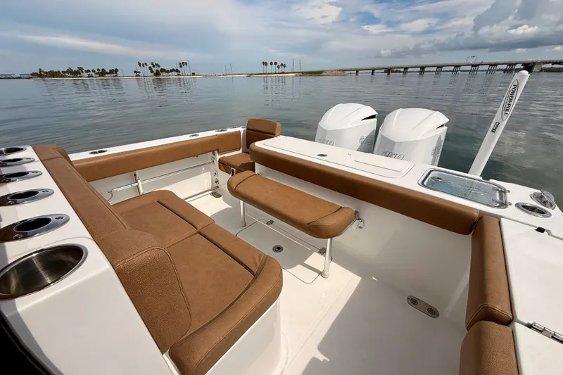 Slide: The Image of 2021 Sea Hunt Gamefish 27FS boat interior with brown seating and twin engines. - 17