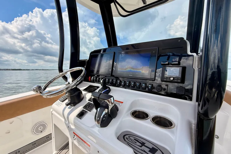 Slide: The Image of 2021 Sea Hunt Gamefish 27FS helm with advanced navigation displays and controls. - 10