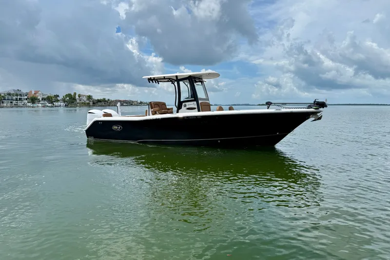 Slide: The Image of 2021 Sea Hunt Gamefish 27FS boat on calm water under cloudy sky. - 20