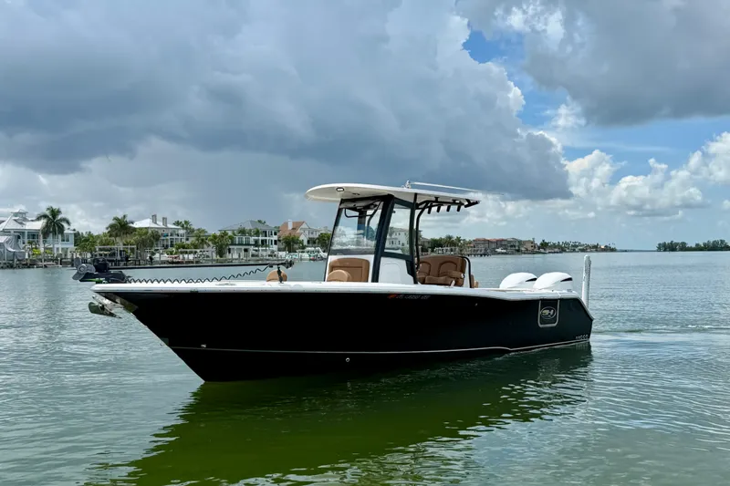 Slide: The Image of 2021 Sea Hunt Gamefish 27FS boat on calm water under cloudy sky. - 27