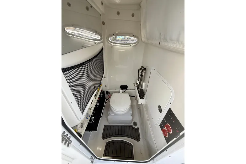 Slide: The Image of Interior of 2021 Sea Hunt Gamefish 27FS boat, featuring a compact marine toilet. - 30