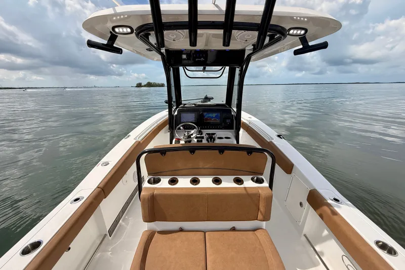 Slide: The Image of 2021 Sea Hunt Gamefish 27FS boat interior with helm, seating, and ocean view. - 3