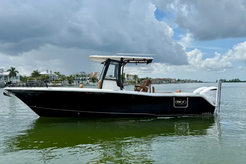 Slide: The Image of 2021 Sea Hunt Gamefish 27FS boat on calm water under cloudy sky. - 21