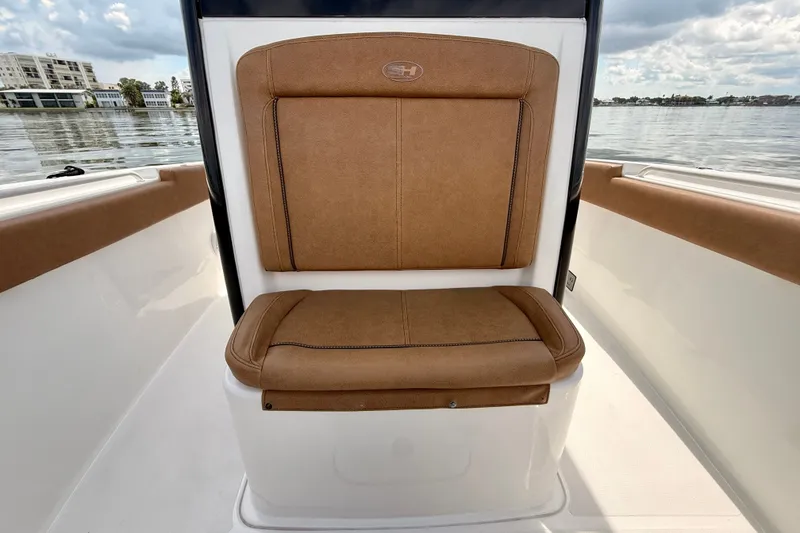 Slide: The Image of 2021 Sea Hunt Gamefish 27FS boat seat with brown upholstery on calm water. - 15