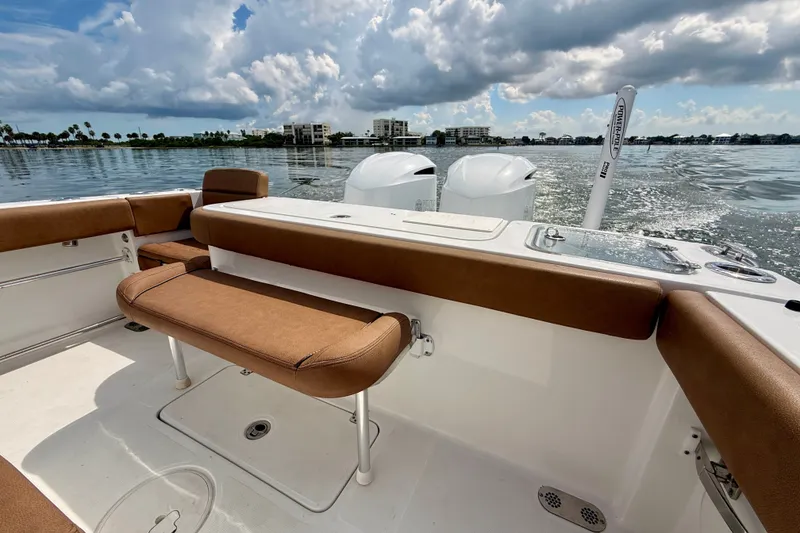Slide: The Image of 2021 Sea Hunt Gamefish 27FS boat interior with brown seating, on calm water. - 18