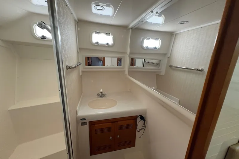 Slide: The Image of Bathroom interior of a 2006 Cabo 35 Flybridge yacht with sink and portholes. - 15